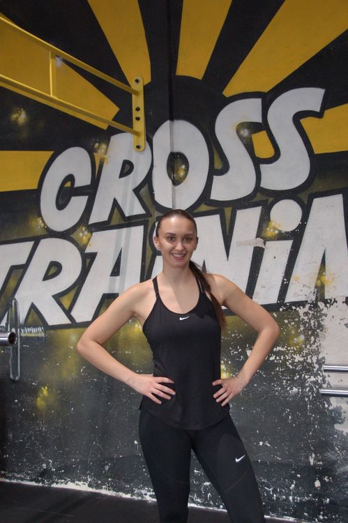 Ella Noly, coach sportive à domicile, devant le mur Cross Training