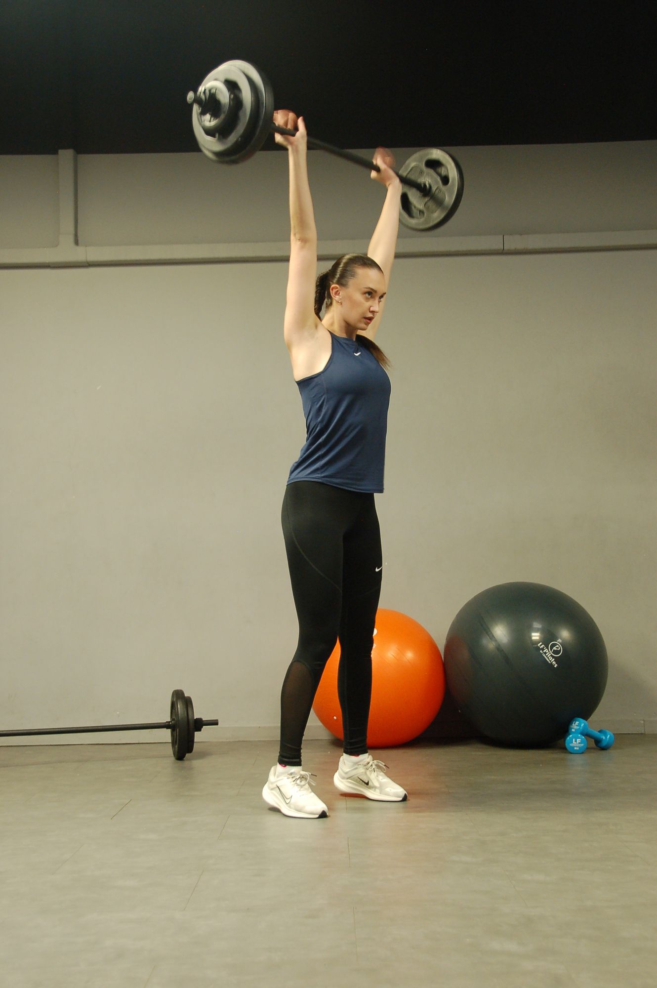 Ella Noly, coach sportive, en développé militaire à la barre lors d'une séance Force & Forme
